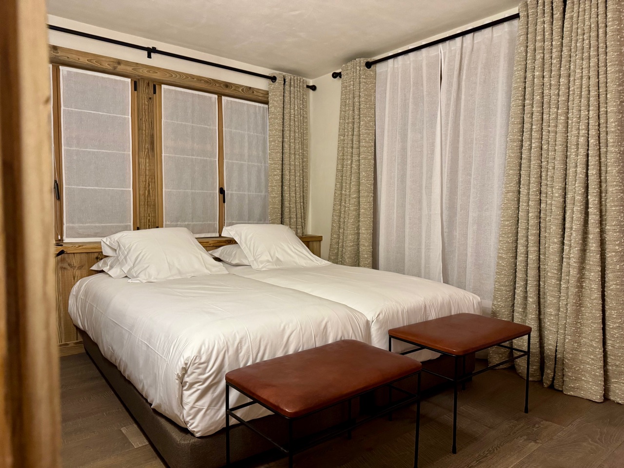 Chambre double avec linge blanc et bancs cuir