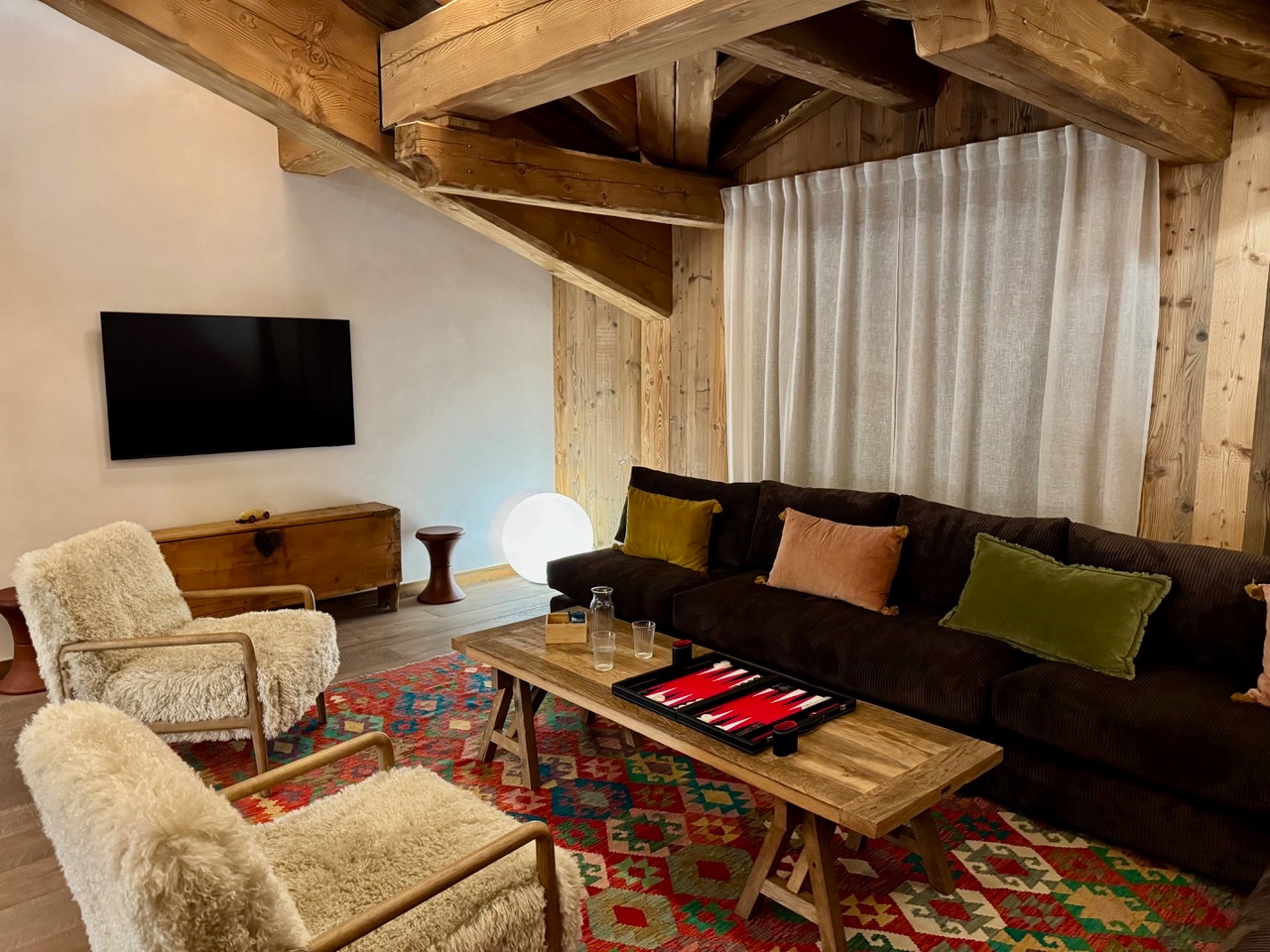 Appartement 4 – duplex, séjour avec poutres apparentes et tapis kilim